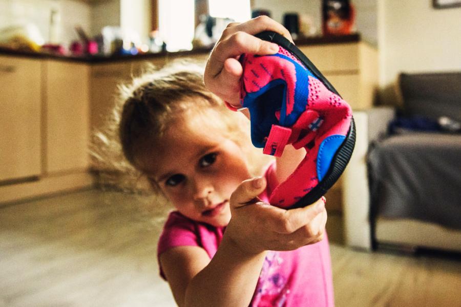 Dziewczynka zgina barefootowe buty dla dzieci producenta Feelmax