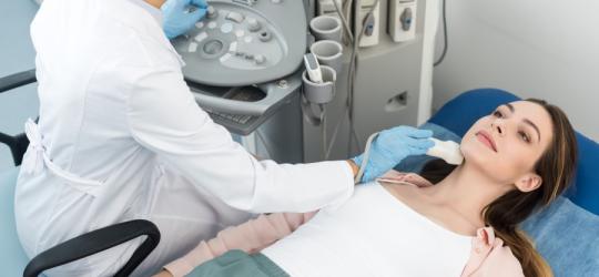 Pacjentka w gabinecie lekarskim w trakcie USG ślinianek.