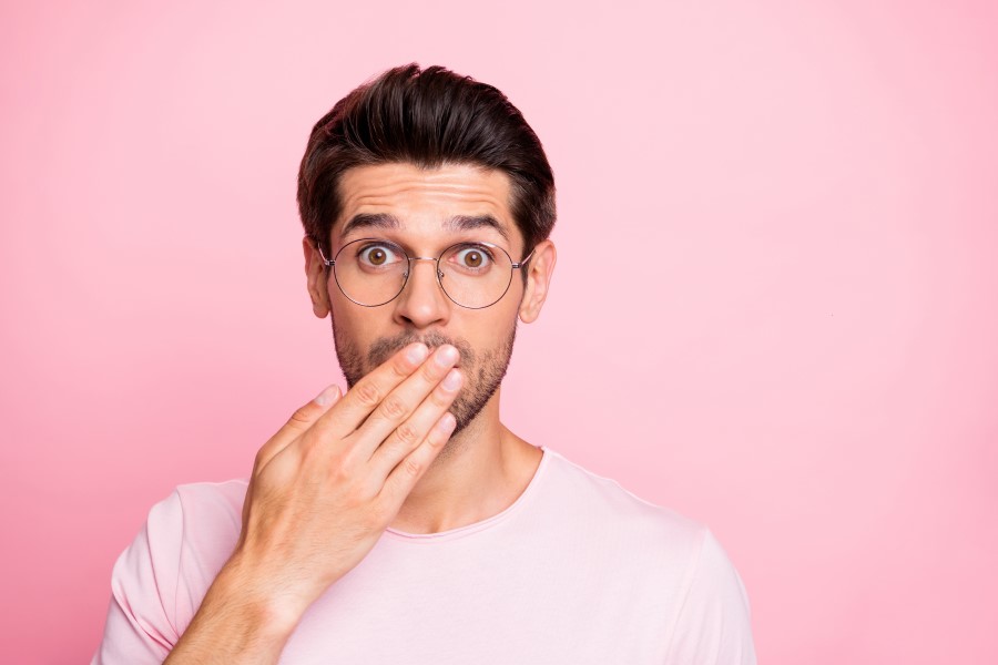 Mężczyzna przykłada dłoń do ust, doskwierają mu afty.