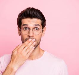 Mężczyzna przykłada dłoń do ust, doskwierają mu afty.