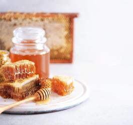 Różne produkty pszczele (miód, plaster miodu, pyłek) stosowane w apiterapii.