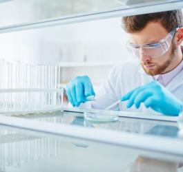 Laborant w okularach ochronnych i rękawiczkach, wykonuje swoją pracę.