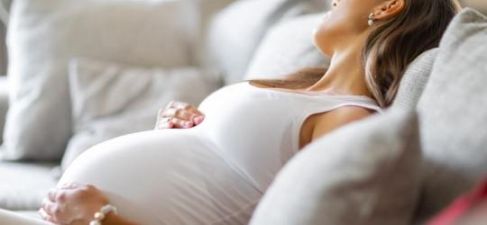 Ciężarna kobieta odpoczywa na kanapie.