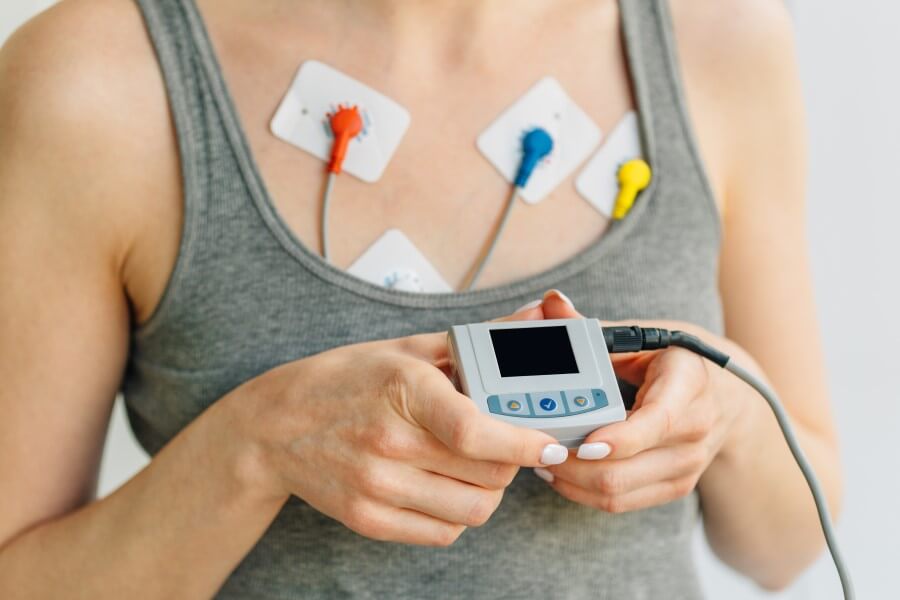Pacjentka prezentuje urządzenie do badania EKG metodą Holtera.