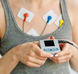 Pacjentka prezentuje urządzenie do badania EKG metodą Holtera.