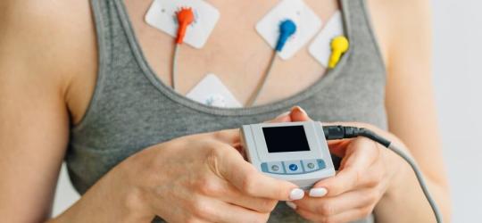 Pacjentka prezentuje urządzenie do badania EKG metodą Holtera.