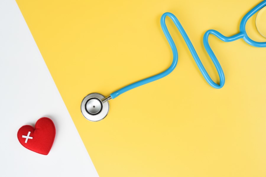 Chore serce i stetoskop układający się w kształt elektrokardiogramu.