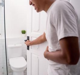 Mężczyzna wchodzi do toalety, męczy go biegunka po jedzeniu.