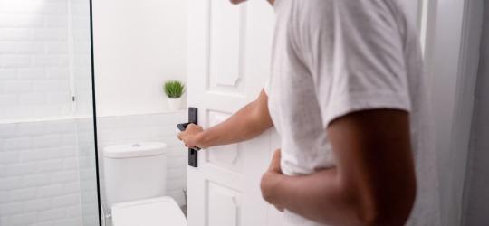 Mężczyzna wchodzi do toalety, męczy go biegunka po jedzeniu.