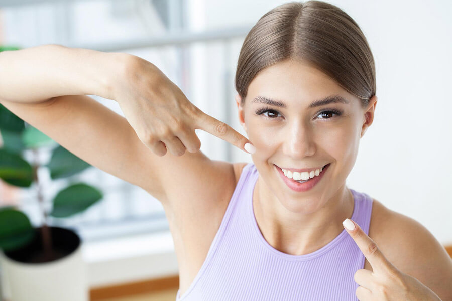 Uśmiechnięta kobieta chwali się wybielonymi zębami.