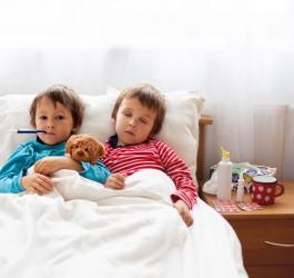 Mali chłopcy leżą w łóżku z gorączką, przechodzą chorobę bostońską.