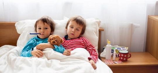 Mali chłopcy leżą w łóżku z gorączką, przechodzą chorobę bostońską.