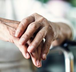 Dłonie starszej kobiety chorującej na chorobę Parkinsona.