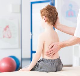 Dziecko u lekarza podczas diagnostyki choroby Scheuermanna.