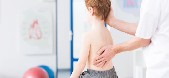 Dziecko u lekarza podczas diagnostyki choroby Scheuermanna.