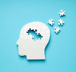 Ludzka głowa ułożona z puzzli. Znikające puzzle symbolizują chorobę neurodegeneracyjną.