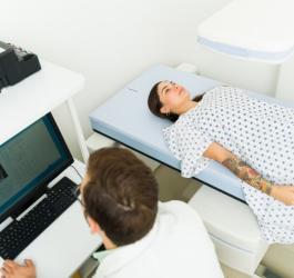 Lekarz wykonuje densytometrię u pacjentki.