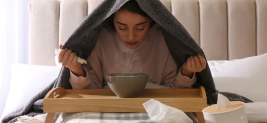 Kobieta wykonuje inhalację nad miską gorącej, parującej wody.