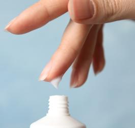 Kobieta nabiera dłonią emolient.