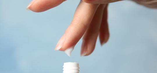 Kobieta nabiera dłonią emolient.