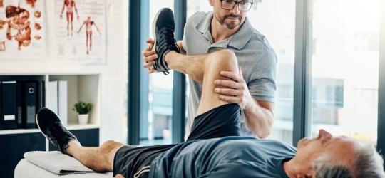 Fizjoterapeuta podczas rehabilitacji z pacjentem.