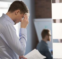 Mężczyzna cierpiący na robię społeczną, stresuje się przed wystąpieniem publicznym.