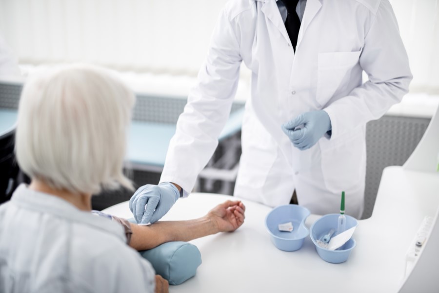 Starsza kobieta przygotowuje się do badania gazometrii krwi.