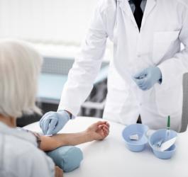 Starsza kobieta przygotowuje się do badania gazometrii krwi.