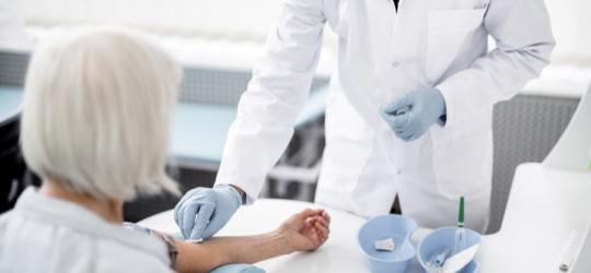 Starsza kobieta przygotowuje się do badania gazometrii krwi.