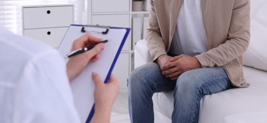 Mężczyzna jest w gabinecie urologicznym, czeka na badanie.