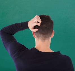 Mężczyzna drapie się po głowie, może chorować na grzybicę skóry głowy.