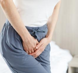 Kobieta trzyma się za krocze, doświadcza objawów infekcji intymnej.