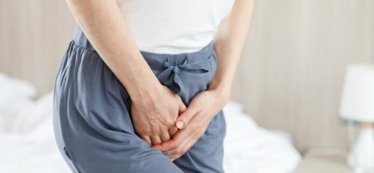 Kobieta trzyma się za krocze, doświadcza objawów infekcji intymnej.