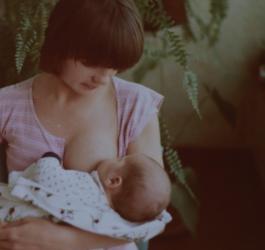 Mama karmi niemowlę piersią.