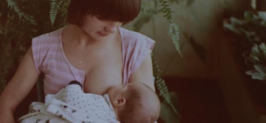 Mama karmi niemowlę piersią.