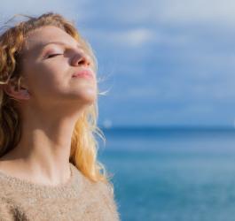 Kobieta wygrzewa się w promieniach słońca.