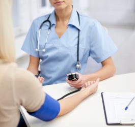 Lekarka w gabinecie bada pacjentce , czy ma prawidłowe tętno i ciśnienie.