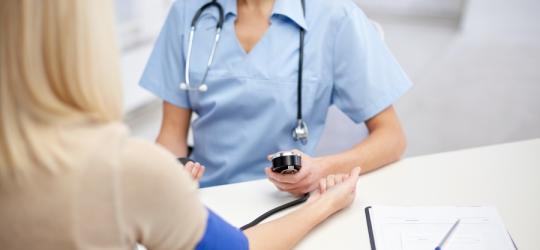 Lekarka w gabinecie bada pacjentce , czy ma prawidłowe tętno i ciśnienie.