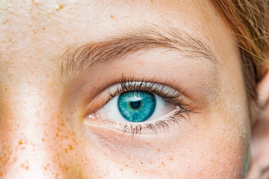 Zbliżenie na oko kobiety o niebieskiej tęczówce.