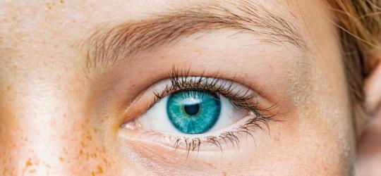 Zbliżenie na oko kobiety o niebieskiej tęczówce.