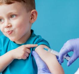 Pewny siebie chłopiec podczas iniekcji szczepionki przez pracownika medycznego.