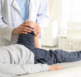 Dziecko w gabinecie ortopedycznym podczas diagnostyki koślawości kolan.