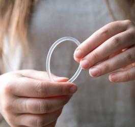 Kobieta trzyma w dłoniach krążek antykoncepcyjny.