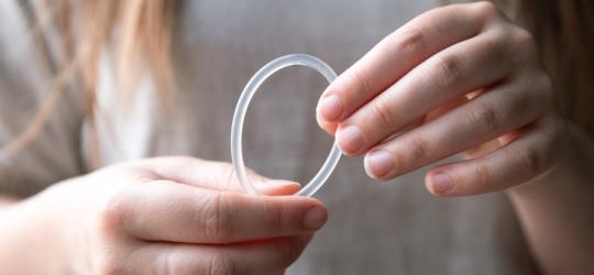 Kobieta trzyma w dłoniach krążek antykoncepcyjny.