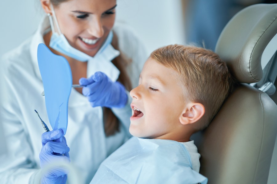 Dziecko u stomatologa przez lakowaniem zębów.