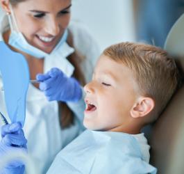 Dziecko u stomatologa przez lakowaniem zębów.