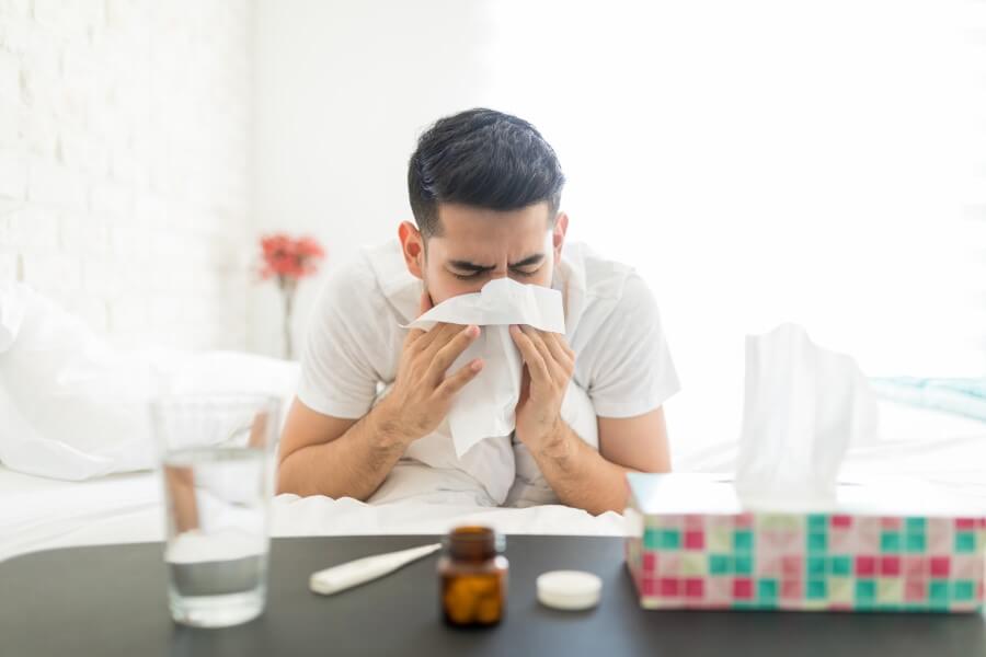 Przeziębiony mężczyzna jest w trakcie objawowego leczenia infekcji wirusowej.