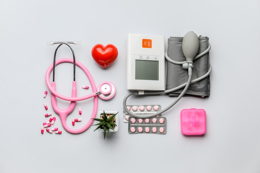 Leki na nadciśnienie obok ciśnieniomierza, stetoskopu i kasetki na leki.