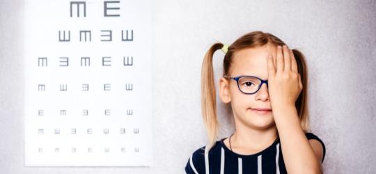 Dziewczynka podczas badania okulistycznego. W ten sposób diagnozuje się m.in. leniwe oko.