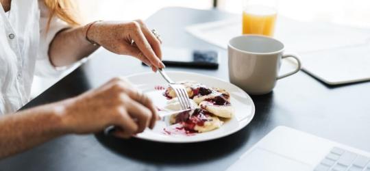Kobieta spożywa posiłek.